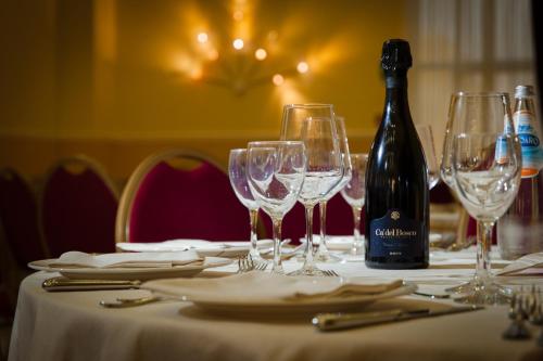 a table with glasses and a bottle of wine at Zanhotel Centergross in Bentivoglio