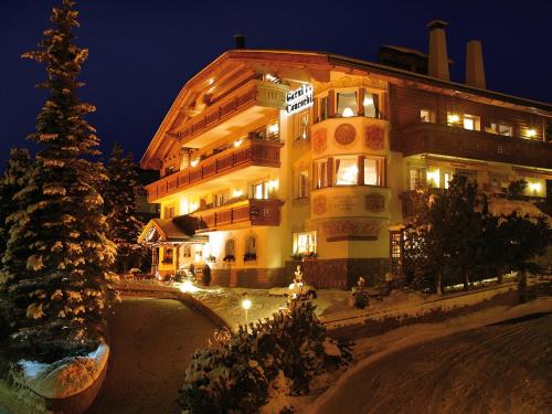 a large building with a christmas tree in front of it at Hotel Garni Concordia - Dolomites Home in Selva di Val Gardena