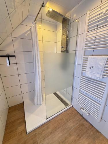 a shower with a glass door in a bathroom at Ferienhaus zur Knock in Emden