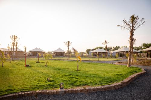 a park with green grass and palm trees at Sangam Farms in Bhilwara