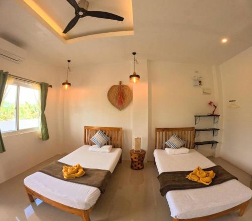 two beds in a room with a window at Divers Lodge Plumeria in Moalboal
