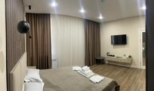 a hotel room with a bed with towels on it at Silkway Deluxe 1 in Semey