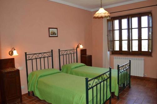a bedroom with two beds with green sheets at Apartment in Asciano - Toskana 50686 in Asciano