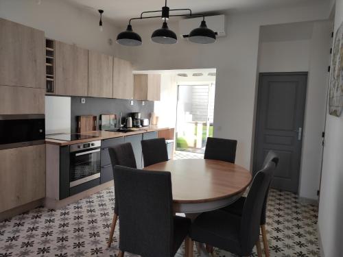 une cuisine avec une table et des chaises en bois dans l'établissement Villa Maris Stella à 250m de la plage de Petit Fort Philippe, à Gravelines