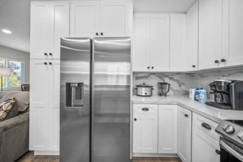 a kitchen with white cabinets and a stainless steel refrigerator at Modern Oasis New 2BR in La Mesa in La Mesa