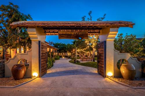 an entrance to a house with a pathway with vases at LÀNG MẮM - PAMY Homestay 2 in Phú Hiệp