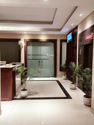 a lobby with a glass door with potted plants at The Pearl Hotel Sirsa in Sirsa