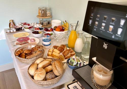 Villa Nieuwland B&B في دن أوفر: طاولة مليئة بسلال الخبز والأطعمة الأخرى