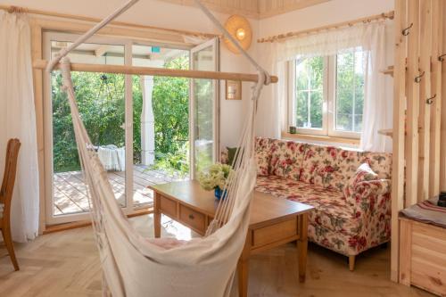 a hammock in the living room of a house at Niebieski Domek nad Marychą in Stanowisko