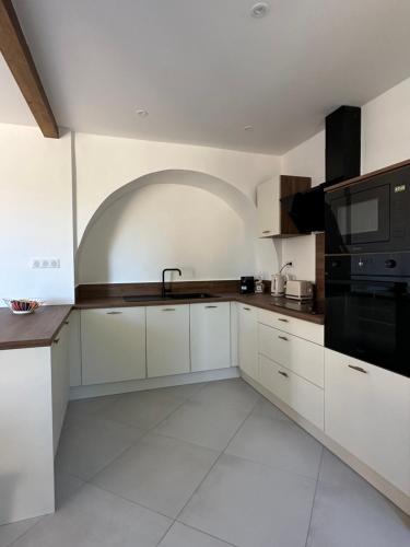 La cuisine est équipée de placards blancs et d'un four micro-ondes noir. dans l'établissement Casa Serena, à Ville-di-Paraso