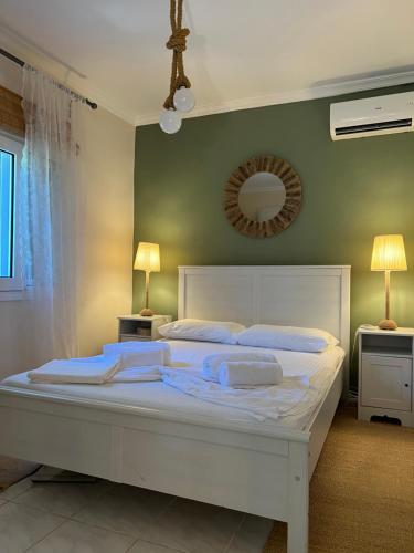 a large white bed in a bedroom with a mirror at Villa Terrina in Áyioi Apóstoloi
