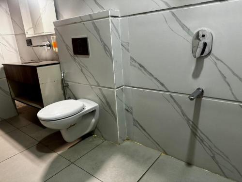 a bathroom with a white toilet and a sink at The Pearl Hotel Sirsa in Sirsa