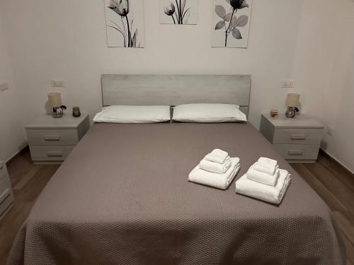 a bedroom with a large bed with towels on it at Villa pirastu in Bassacutena