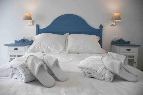 a bed with white towels and shoes on it at X C Apartamentos Morales & Arnal in Ronda