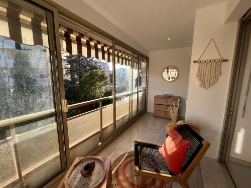 サント・マキシムにあるSuperbe 70m2 avec terrasses, proche de la plageのリビングルーム(大きな窓、椅子付)