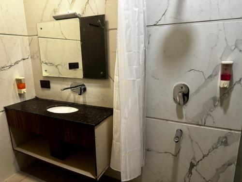 a bathroom with a sink and a mirror at The Pearl Hotel Sirsa in Sirsa