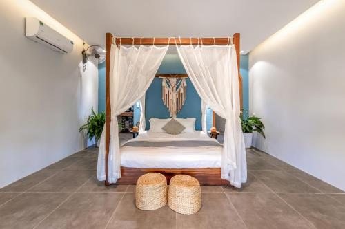 a bedroom with a canopy bed and two baskets at LÀNG MẮM - PAMY Homestay 2 in Phú Hiệp