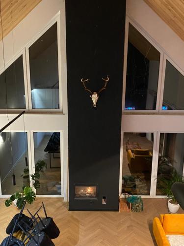 a room with a wall with a deer head on the wall at Ostoja Skarlin in Mikołajki Pomorskie
