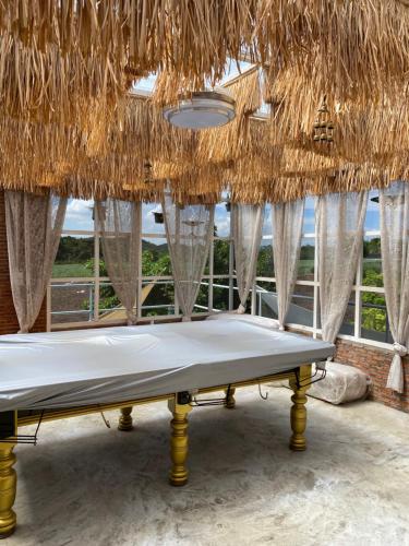 a mattress in a room with a straw roof at Daiya Pool Villa, Khaoyai in Ban Sathani Phut Rai