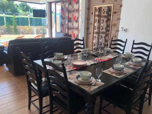 a dining room table with chairs and a tableclotholitics at Daiya Pool Villa, Khaoyai in Ban Sathani Phut Rai