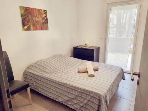 Un dormitorio con una cama con dos toallas encima. en Grand appartement avec garage et terrasse, en Castelnau-le-Lez