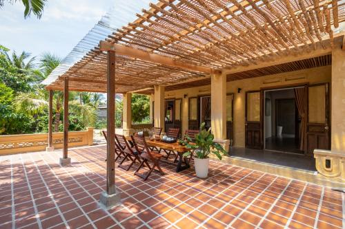 an outdoor patio with a wooden table and chairs at LÀNG MẮM - PAMY Homestay 2 in Phú Hiệp