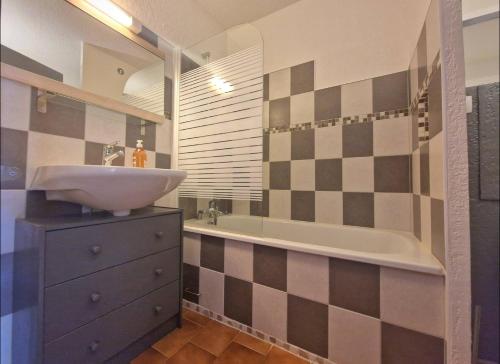 une salle de bain avec un lavabo et une baignoire dans l'établissement Studio piscine, proche mer, parking privé, à Bandol