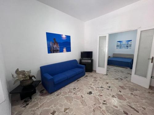 a living room with a blue couch and a bed at Casa di Pippo in Trappeto
