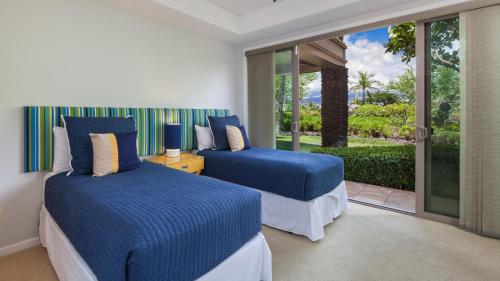 a bedroom with two beds and a large window at SLICE OF PARADISE Well-Appointed 4BR KaMilo Home with Private Beach Club in Waikoloa
