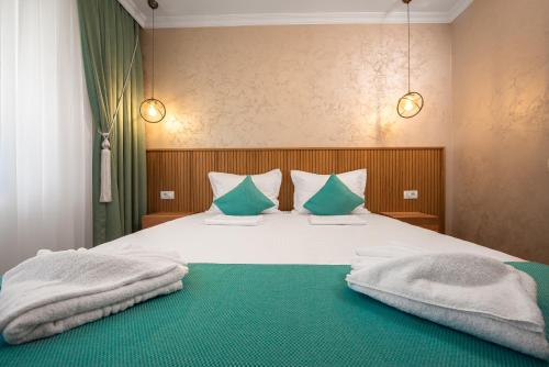 a bedroom with a bed with blue and white pillows at Thaya Rooms in Mangalia