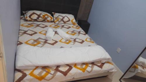a bed with a white comforter and pillows at AYAAN FAMILY HOMESTAY FREE WiFi in Tanah Rata