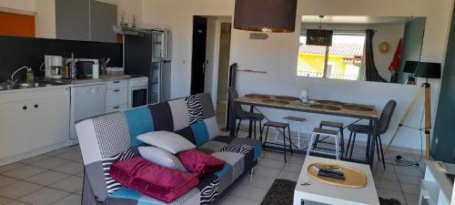 un salon avec un canapé et une cuisine dans l'établissement Appartement vue mer Aiguebelle, au Lavandou