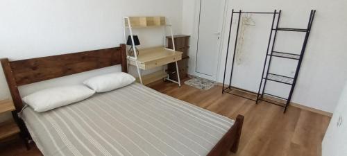 a bedroom with a bed and a desk with two shelves at Стаи за гости Пансионът на Роуз Вълшебната ми Кръстница in Chernomorets