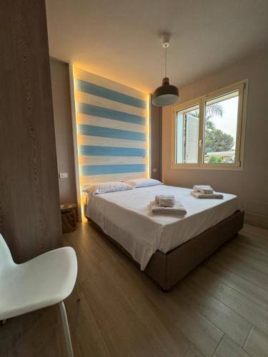 a bedroom with a large bed and a window at Pescoluse Apartments in Marina di Pescoluse