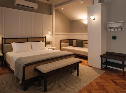 a bedroom with a bed and a bench in it at Noordin Mews in George Town