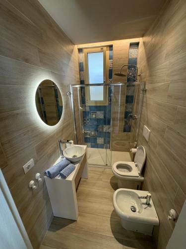 a bathroom with a sink and a toilet and a mirror at Pescoluse Apartments in Marina di Pescoluse