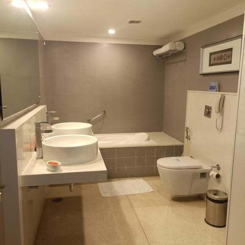 a bathroom with a sink and a toilet at Royal Park Kakinada in Kākināda