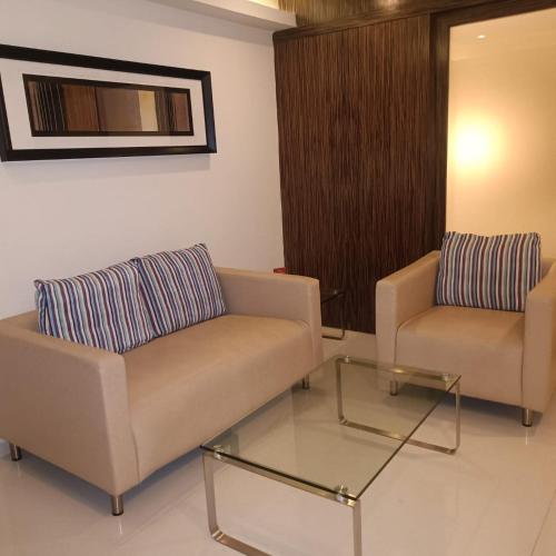 a living room with two couches and a glass table at Royal Park Kakinada in Kākināda