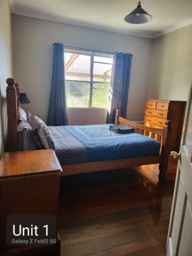 a bedroom with a bed with a blue comforter and a window at Bunbury's Most Convenient Location in Bunbury