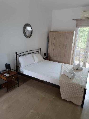 a bedroom with a bed and a clock on the wall at Ascension Corfu Studios by GuestCorfu in Análipsis
