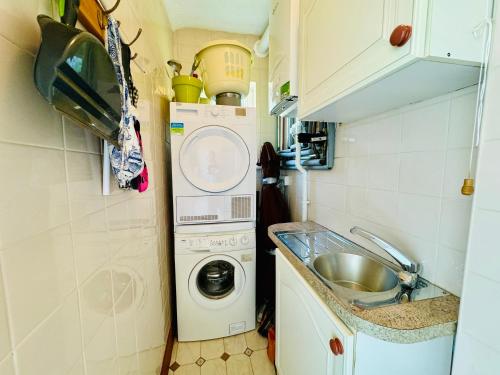a small kitchen with a washing machine and a sink at TIRNANT- 3 Bed - GROUND FLOOR ROOMS -DOG FRIENDLY in Trearddur
