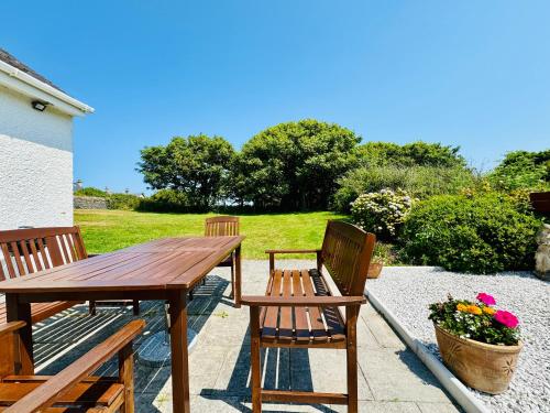 a wooden table and chairs on a patio at TIRNANT- 3 Bed - GROUND FLOOR ROOMS -DOG FRIENDLY in Trearddur