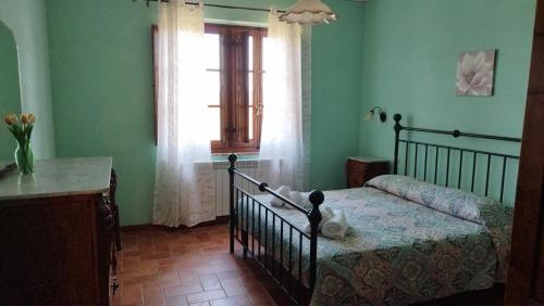 a bedroom with a bed and a window and a table at Agriturismo Caliano in Asciano