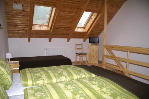 a bedroom with a bed and two windows at Öregtölgy Panzio in Csongrád