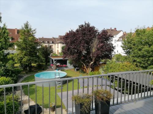 a balcony view of a yard with a swimming pool at Premium Ferienwohnung "Christine ", Zentrale ruhige Stadtlage 100 QM Ebenerdige Dusche Terasse Kaminofen in Zweibrücken