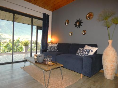 a living room with a blue couch and a table at Villa VETYVER de CILAOS in Cilaos