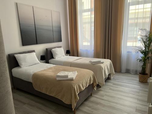 a hotel room with two beds and a mirror at Apartamenty Przy Deptaku in Świnoujście