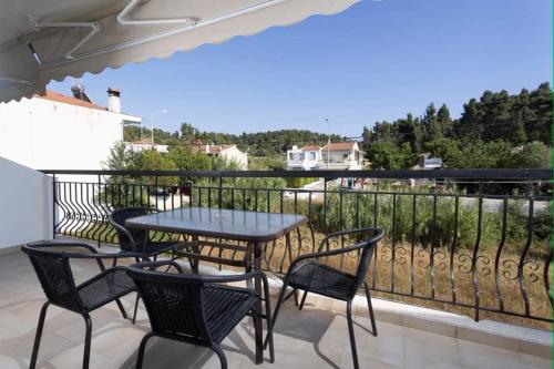 a patio with a table and chairs on a balcony at Μυρτιές-Mirties in Siviri