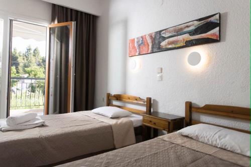 a hotel room with two beds and a window at Μυρτιές-Mirties in Siviri