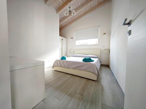 una camera da letto bianca con un letto e una finestra di villa ELEGANCE charming PORTO PINO a Porto Pino